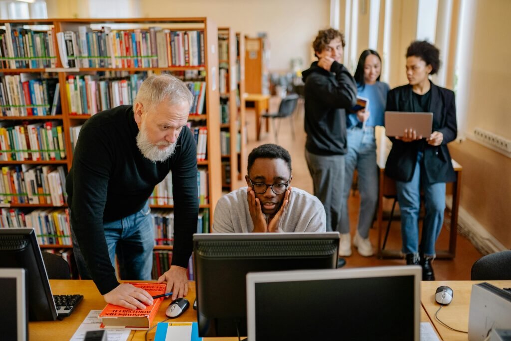 Students and a mentor collaborate in a university library, engaging in educational activities.